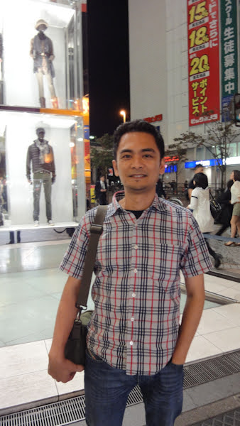a filipino man in a plaid shirt with short dark hair